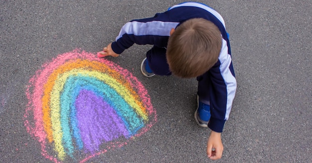 Disegna un'auto del sole arcobaleno con il gesso sull'asfalto