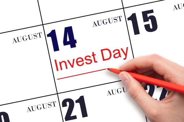 Disegnare a mano la linea rossa e scrivere il testo Invest Day sulla data del calendario 14 agosto Concetto di business e finanziario