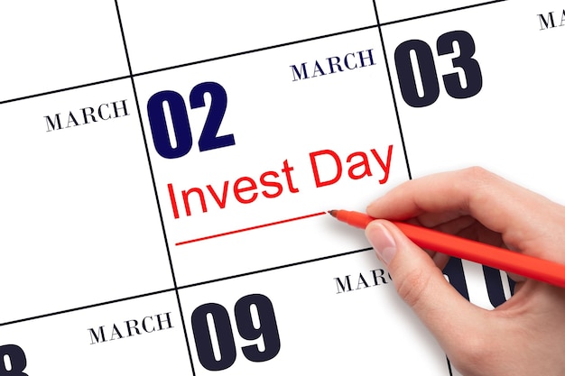 Disegnare a mano la linea rossa e scrivere il testo Invest Day sulla data del calendario 2 marzo Concetto aziendale e finanziario