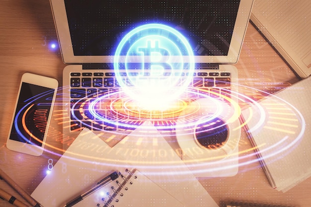 Disegni ologrammi a tema blockchain sul computer sullo sfondo del desktop Vista superiore Esposizione doppia