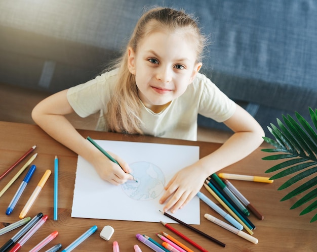 Disegno della ragazza del bambino con le matite colorate