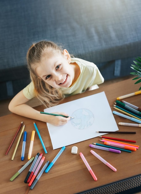 Disegno della ragazza del bambino con le matite colorate