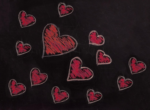 Disegno di cuore rosso sulla lavagna della scuola Simbolo di San Valentino d'amore sulla lavagna nera