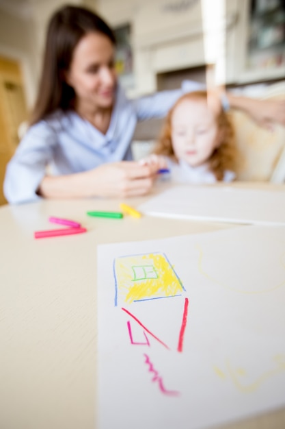 Disegno infantile di casa sul tavolo e sulla famiglia