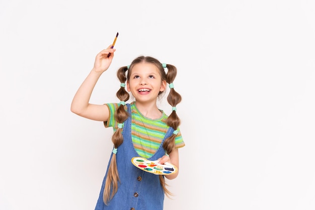 Disegno per bambini Una bambina disegna il tuo annuncio con un pennello su uno sfondo bianco e isolato Corsi per giovani artisti in pittura