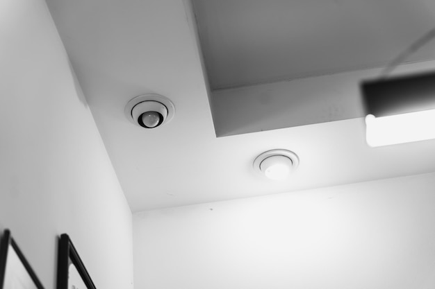Disegno unico del soffitto con apparecchi di illuminazione moderni in una stanza minimalista