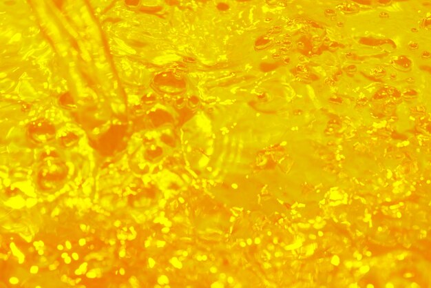 Disfocalizzazione sfocata trasparente giallo colorato chiara texture superficiale dell'acqua calma con spruzzi di riflesso