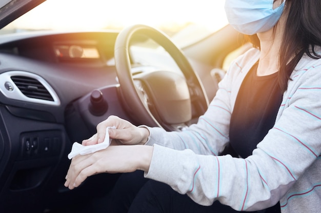 Disinfettante per spruzzatura a mano femminile e salviettine umidificate antisettiche per la disinfezione dell'auto.