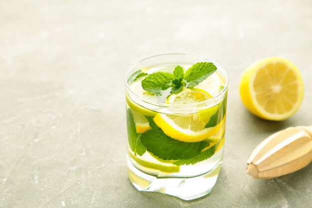 Disintossicazione dell'acqua con limone, lime e menta su uno sfondo grigio cemento. Detox drink con copia spazio