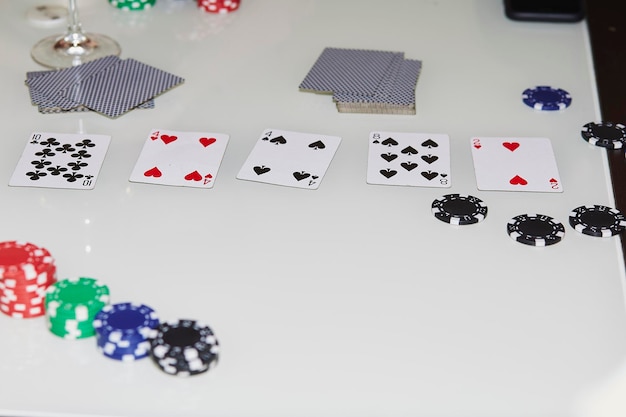 Disporre le carte sul tavolo nel gioco del poker Bicchiere di champagne Concetto di gioco d'azzardo Momento schietto Fotografia di sfondo del poker Messa a fuoco selettiva