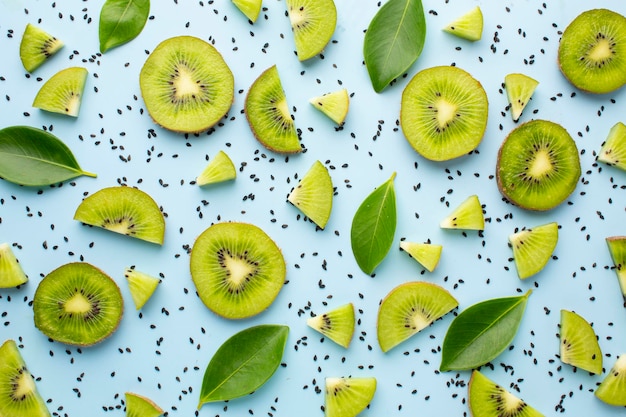 Disporre un kiwi tagliato con semi su uno sfondo solido color acqua Concetto estivo