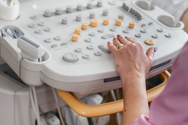 Dispositivo ad ultrasuoni Close-up durante una visita medica di una donna incinta. Visita medica