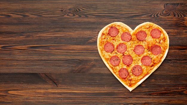 Disposizione adorabile per la cena di San Valentino con pizza a forma di cuore e lo spazio della copia