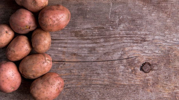 Disposizione delle patate su fondo di legno con lo spazio della copia