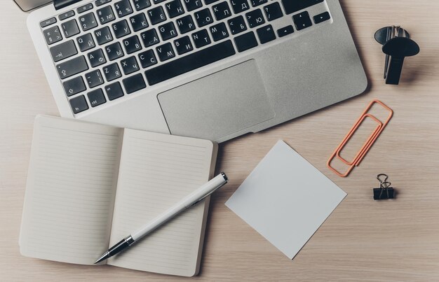 Disposizione dello spazio di lavoro con notebook portatile e articoli di cancelleria su tavolo di legno