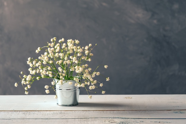 Disposizione di fiori fresca della molla in secchio metallico sulla tavola di legno