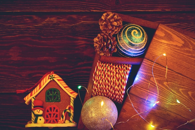 Disposizione di Natale su un fondo di legno. Scatola di legno vintage con giocattoli di Natale. Vista dall'alto, stile piatto.