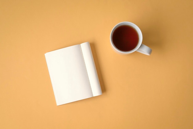 Disposizione piana del blocco note e del caffè sul ripiano del tavolo giallo