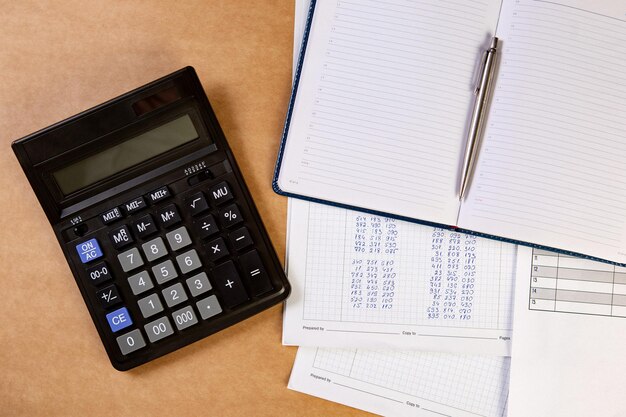 Disposizione piana della calcolatrice con latticini, penna a sfera e documenti sul tavolo.