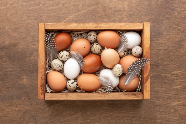 Disposizione piana della scatola con le uova per pasqua su fondo di legno