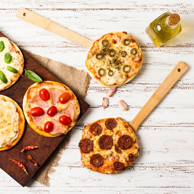 Disposizione piana di mini pizza sul vassoio di legno