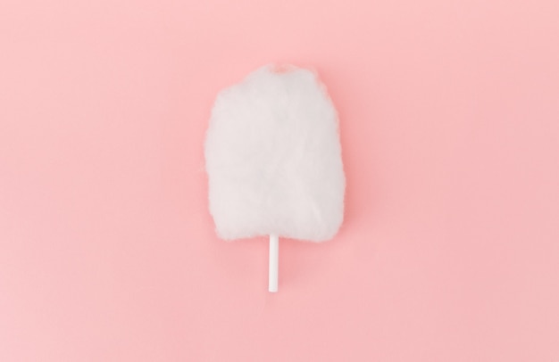 Disposizione piana di zucchero filato isolata su superficie rosa