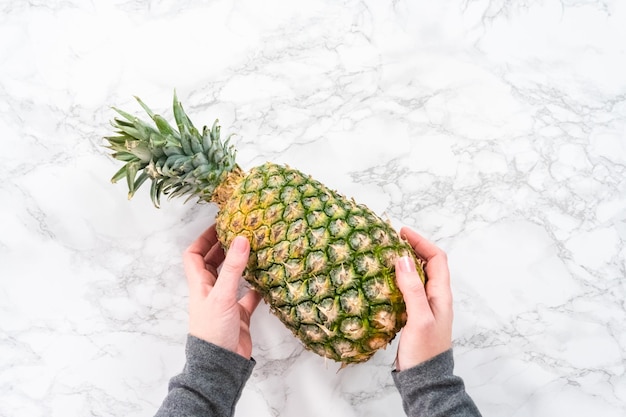 Disposizione piatta. Ananas intero su fondo di marmo.