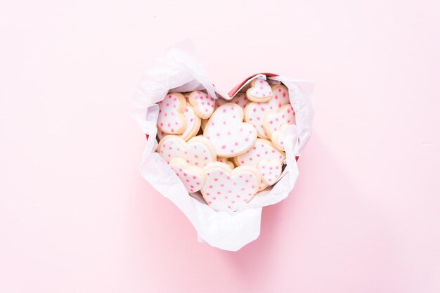 Disposizione piatta. Biscotti di zucchero a forma di cuore decorati con glassa reale in confezione regalo.