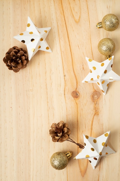 Disposizione piatta di ornamenti natalizi dorati su legno chiaro