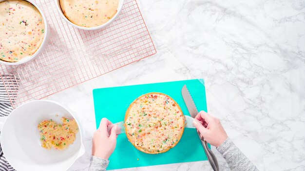 Disposizione piatta. Passo dopo passo. Avvolgere la torta funfetti appena sfornata in cellophane e carta stagnola per la conservazione in congelatore.