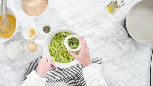 Disposizione piatta. Passo dopo passo. Mescolare gli ingredienti in una ciotola per fare le torte di zucchine.