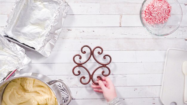 Disposizione piatta. Passo dopo passo. Sciogliere le gocce di cioccolato bianco nella pentola di cottura per fare il fondente al cioccolato bianco di zucchero filato.