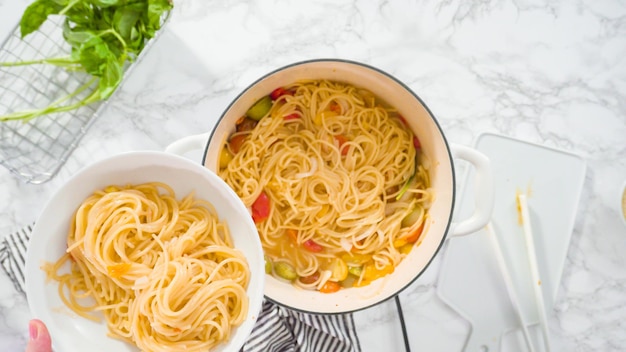 Disposizione piatta. Passo dopo passo. Servire una pasta in un piatto di pasta bianca.