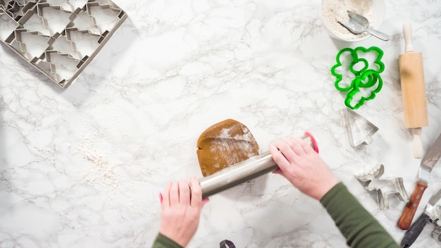 Disposizione piatta. Passo dopo passo. Stendere la pasta biscotto di pan di zenzero per cuocere i biscotti di Natale.