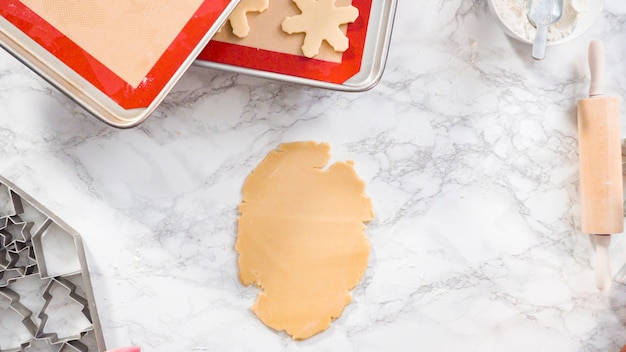 Disposizione piatta. Passo dopo passo. Stendere la pasta per biscotti di zucchero per cuocere i biscotti di Natale.