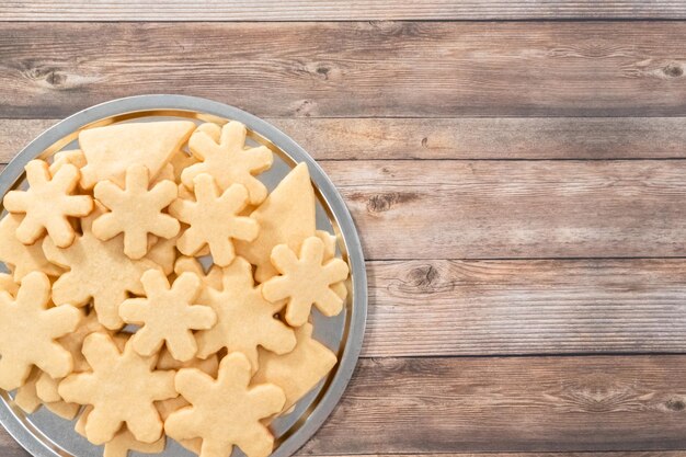 Disposizione piatta. Pila di biscotti di zucchero appena sfornati a forma di fiocco di neve.