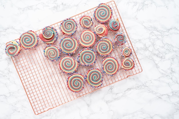 Disposizione piatta. Raffreddare i biscotti di zucchero girandola rossi, bianchi e blu su una griglia di raffreddamento. Dessert per la celebrazione del 4 luglio.