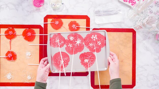 Disposizione piatta. Sbucciare grandi lecca lecca fatti in casa dal tappetino in silicone.