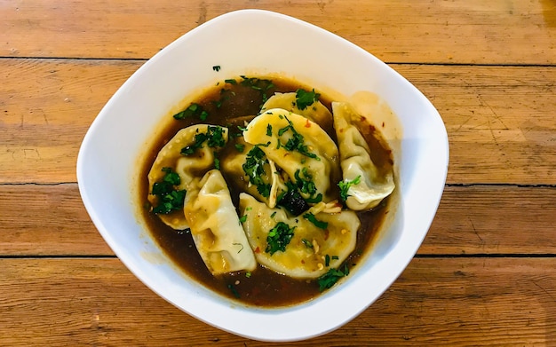 Disposizione piatta Zuppa di gnocchi in tavola di legno