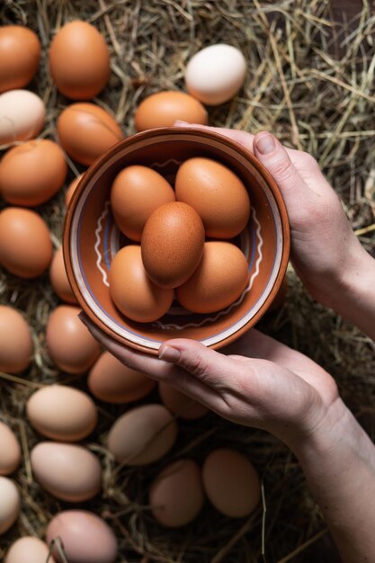 Disposizione verticale piatta La donna tiene in mano una ciotola di uova di gallina fatte in casa Cibo sano