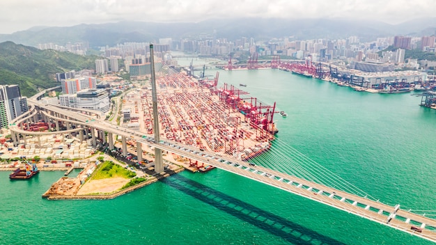 Distretto industriale del porto di Hong Kong con il contenitore di carico e il ponte degli Stonecutters.