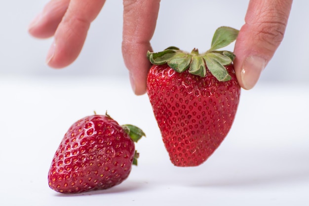 Dita che scelgono uno stile di vita sano di frutta fragola rossa