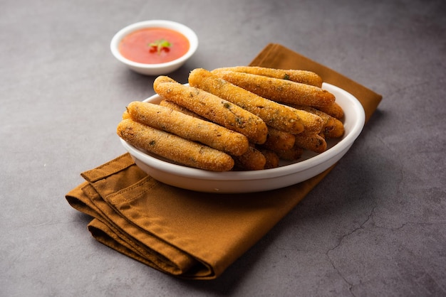 Dita croccanti di Rava Aloo o bastoncini di semola di patate fritti serviti con ketchup