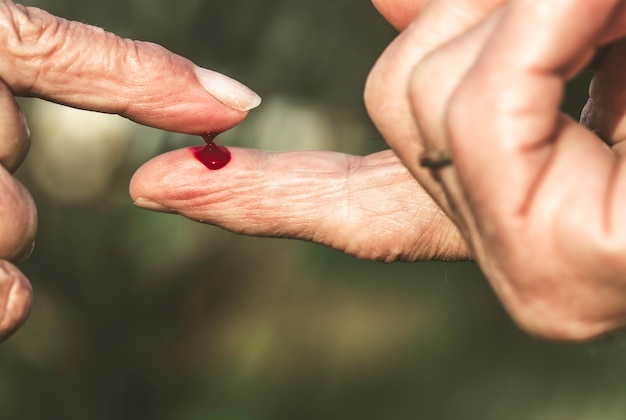 Dita di uomo e donna anziana con sangue