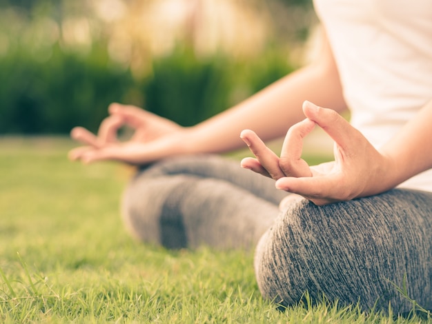 Dito di yoga della donna che si comporta sulle mani con il fondo circostante della natura. Concetto di healthca