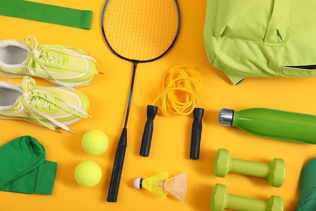 Diverse attrezzature sportive su sfondo giallo piatto