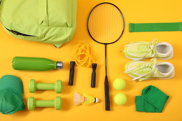 Diverse attrezzature sportive su sfondo giallo piatto