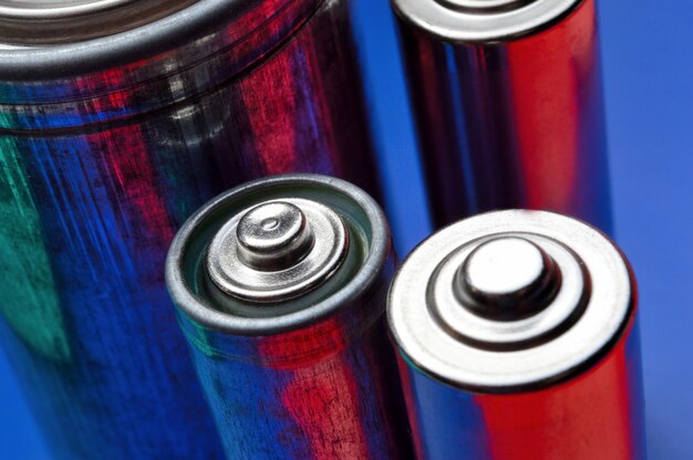 Diverse batterie multicolori su sfondo blu-rosso. avvicinamento.