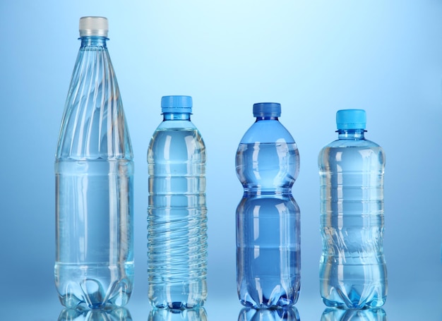 Diverse bottiglie d'acqua su sfondo blu