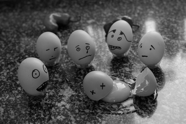 Diverse facce antropomorfe su gusci d'uovo a tavola